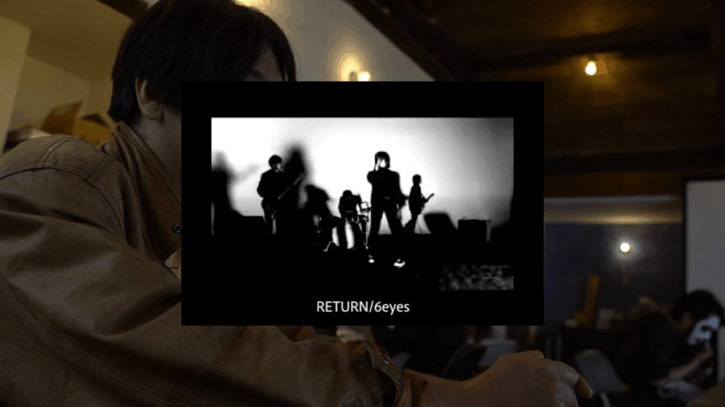 ツチヤチカらを背景に、モニターにバンド6EYESのライブ映像