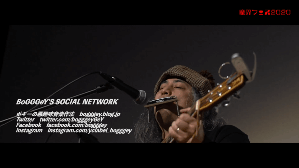 ライブ中のボギー、アコギとハーモニカを演奏するアップショット