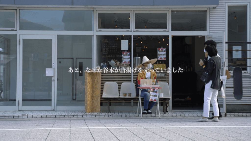 はなあらしの店前でから揚げを手売りしている店主とお客さん