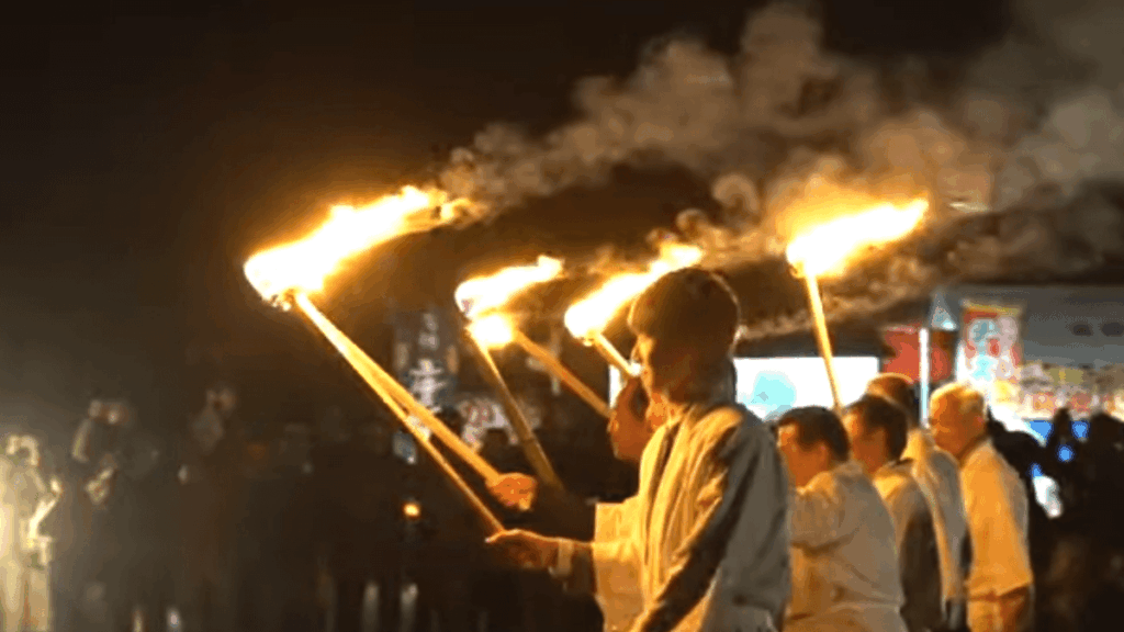 松明を手にした人々がトンドに火を入れる瞬間