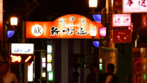 大分県佐伯市、夜の新町通り入口の赤い看板のアップ