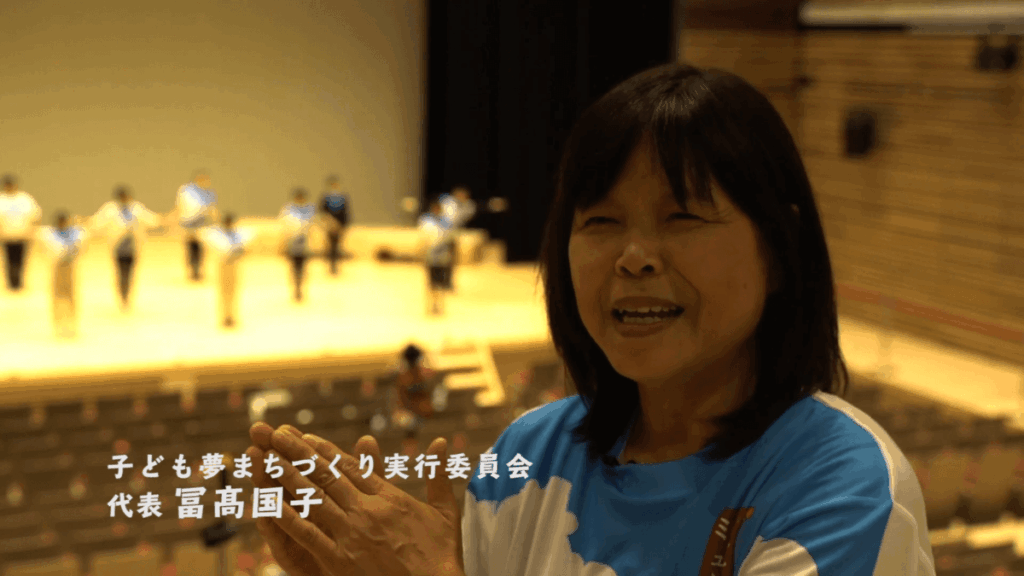 佐伯市の子度も夢まちづくり実行委員会代表がホールで語る様子